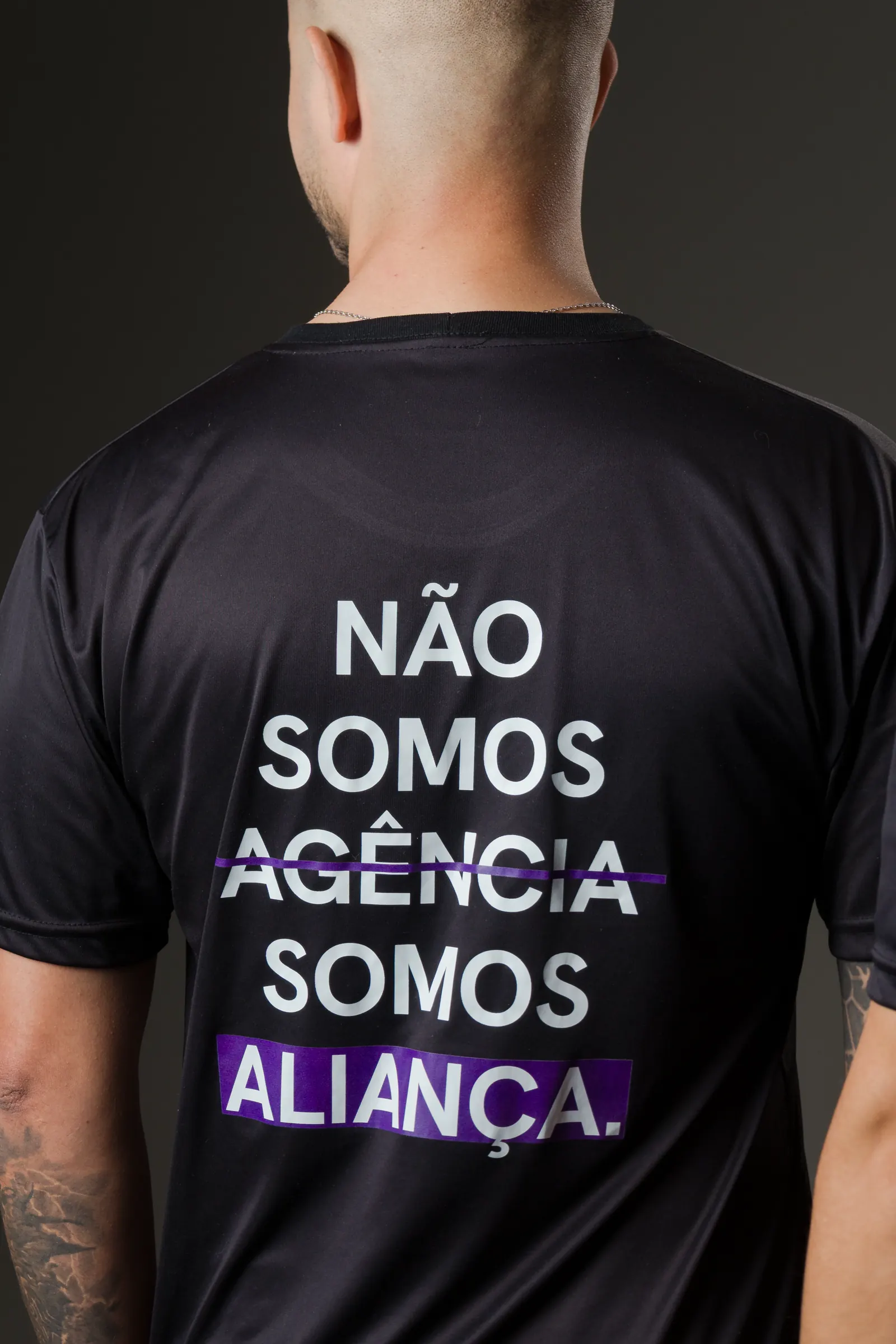 Costas da camiseta oficial do time da Domos com a frase: não somos agência, somos aliança